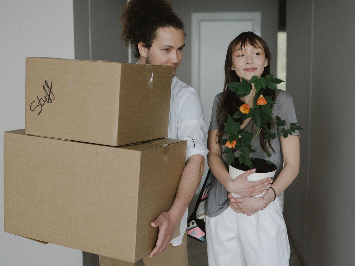 Young couple carrying boxes into their first home