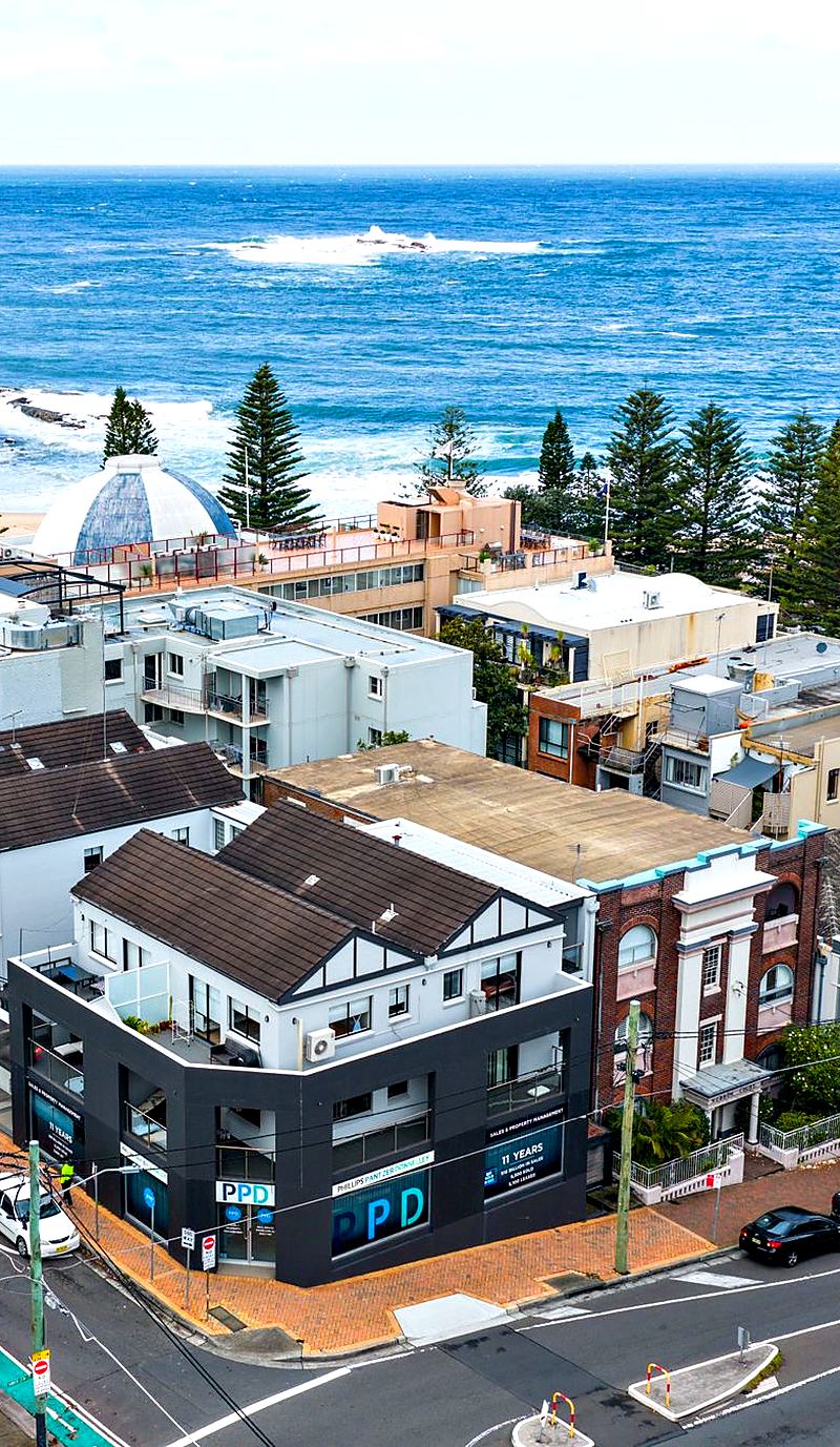 Aerial view over apartment buildings and terraces in Sydney's Eastern Suburbs with the ocean behind