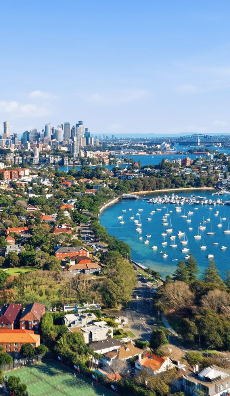 Sydney Harbour and the city skyline seen from the air above the Eastern Suburbs, with boats moored in the bay